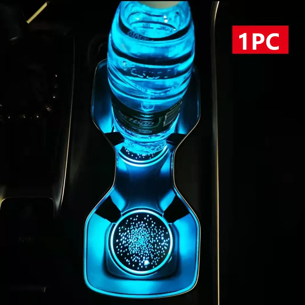 A close-up view of a blue rechargeable LED cup holder light installed in a car interior.