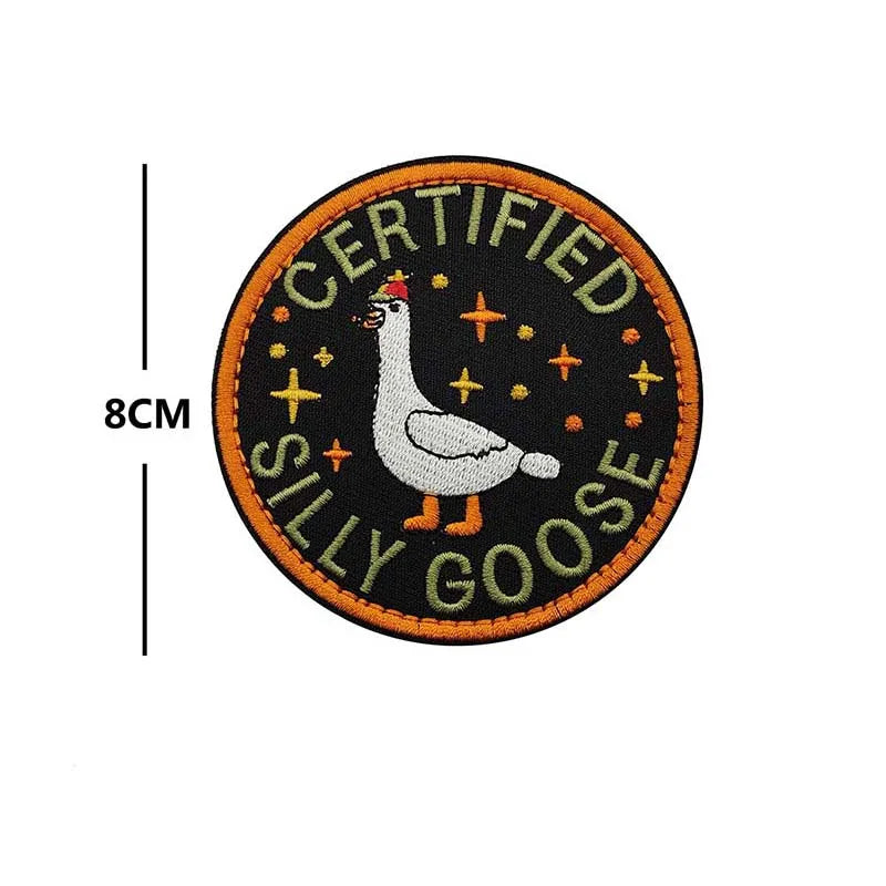 A circular embroidered patch with black background featuring a white goose and the text CERTIFIED SILLY GOOSE
