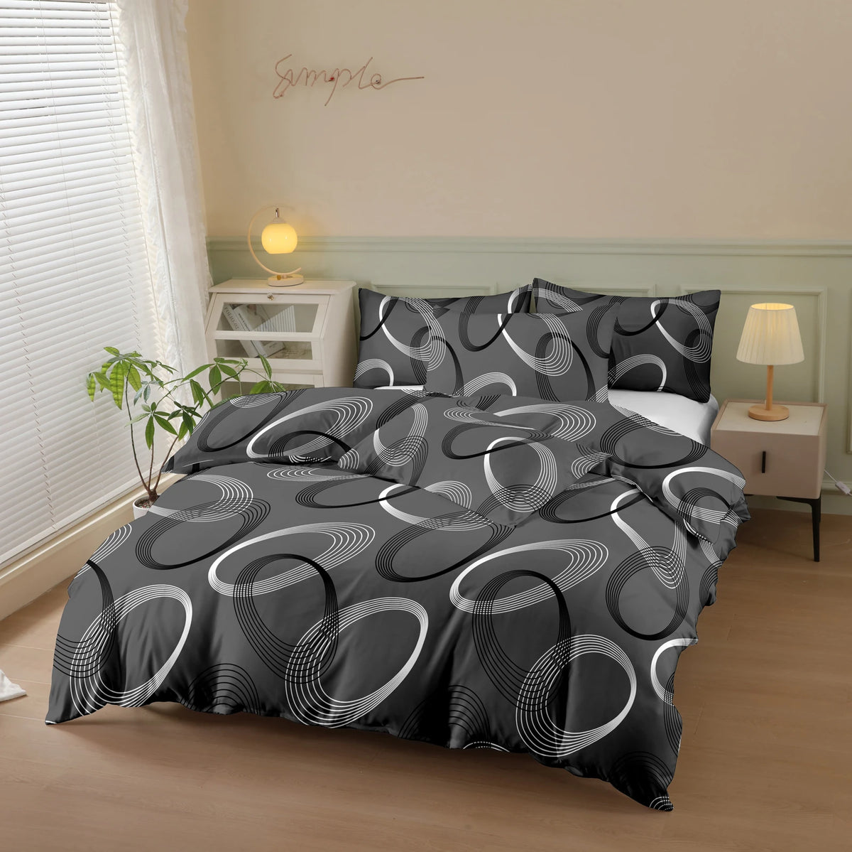 A black and white geometric print duvet cover set with pillows displayed on a bed in a light-colored room.