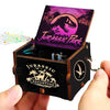 A wooden music box featuring a Jurassic Park theme with a dinosaur silhouette and jungle scenery.