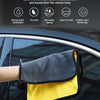 A pair of yellow and gray microfiber car cleaning towels are shown being used on a dark car surface.
