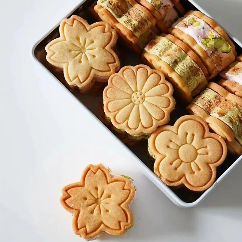 A tray of floral cookie cutters featuring cherry blossom, peach blossom, and sunflower designs.