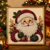 Gerahmtes Gemälde mit Weihnachtsmann mit weißem Perlenbart, umgeben von roten und grünen festlichen Elementen.
