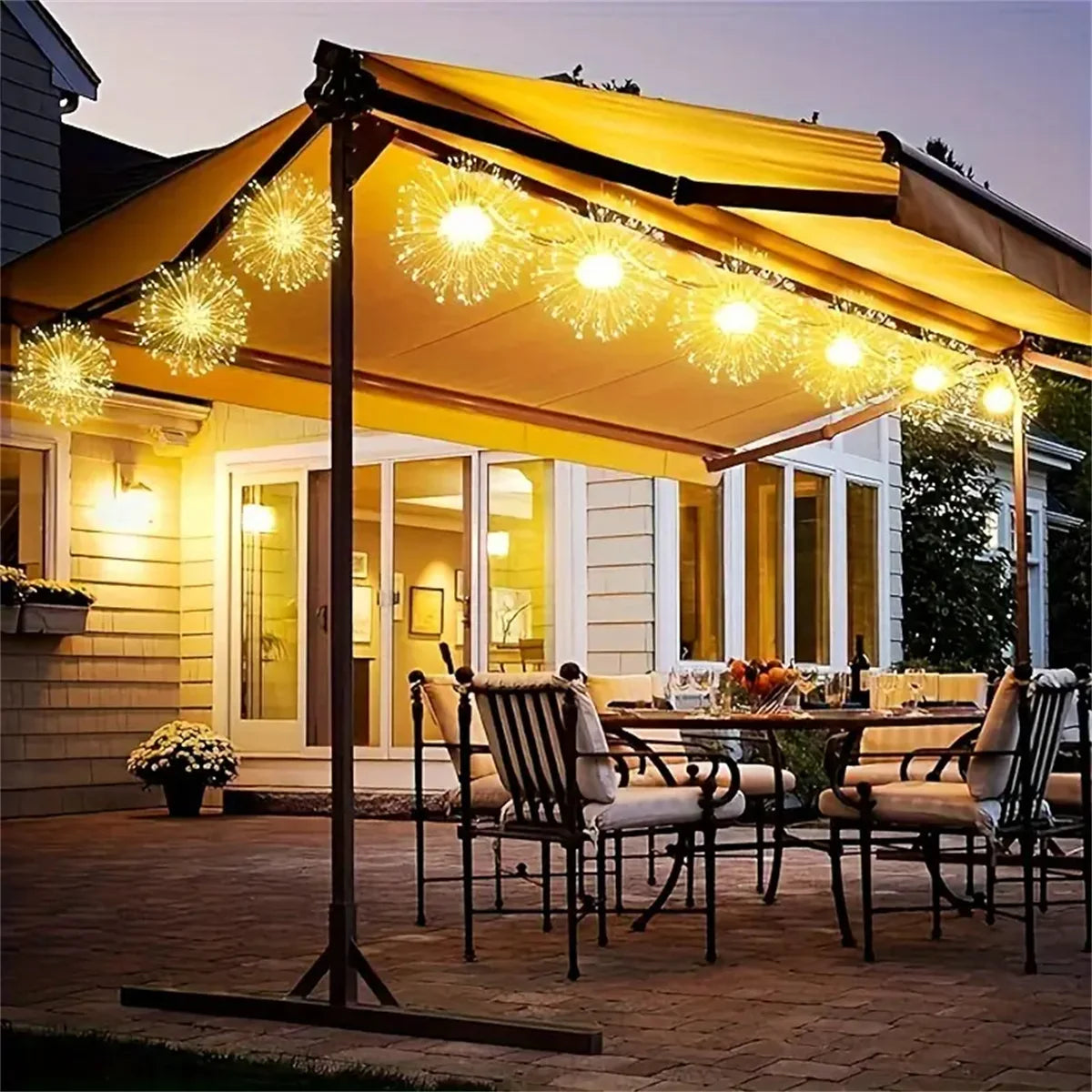 Outdoor dining area featuring a yellow awning and string lights illuminating a patio table.