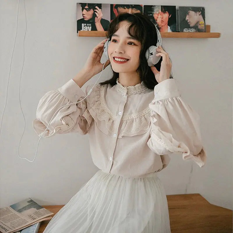 A woman wearing a vintage lace long sleeve blouse and headphones, smiling while looking off-camera.