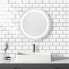A modern bathroom featuring a white vessel sink and a round illuminated mirror mounted on a white subway tile wall.