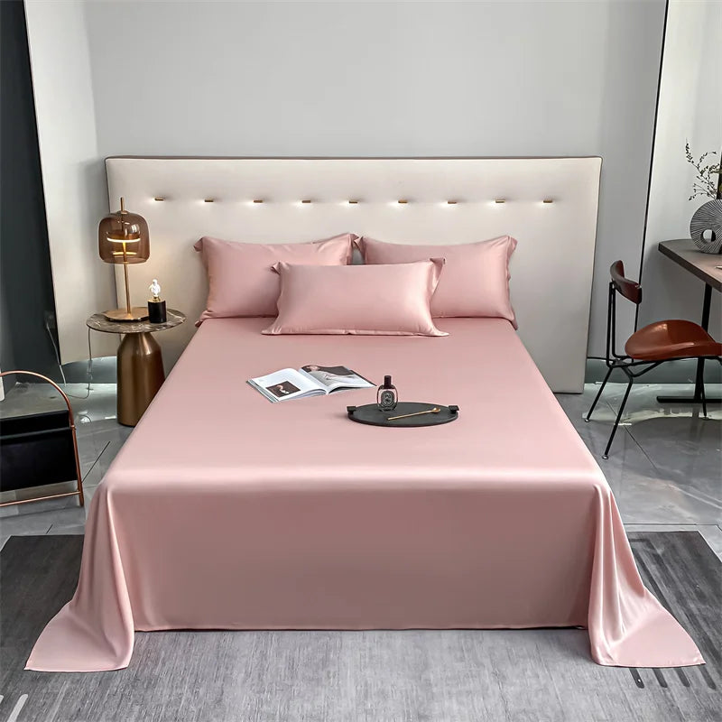 A pink luxury bamboo flat sheet is displayed on a bed with a padded headboard and pillows.