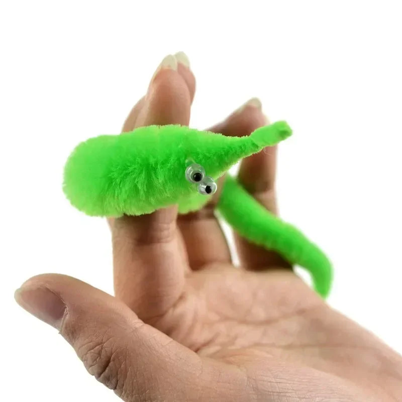 A bright green magic slithering caterpillar trick is held in a person's hand.