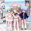 Three articulated BJD collectible figurines in pink and blue outfits displayed in their packaging box.