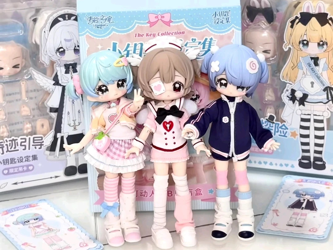 Three articulated BJD collectible figurines in pink and blue outfits displayed in their packaging box.