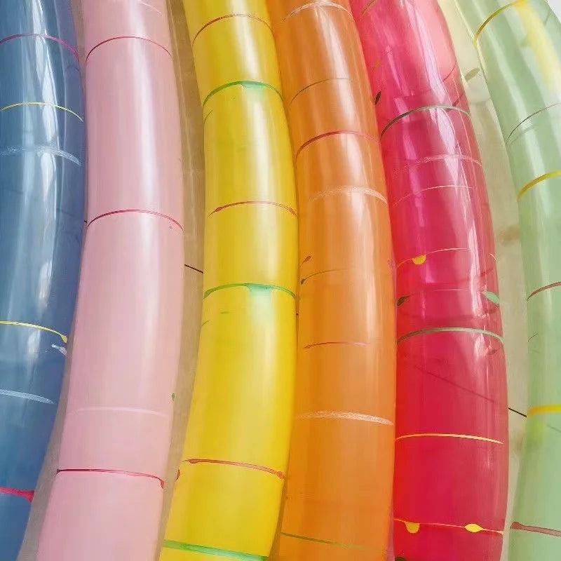 A vertical display of colorful whistling flying party balloons in shades of blue, pink, yellow, orange, and red.