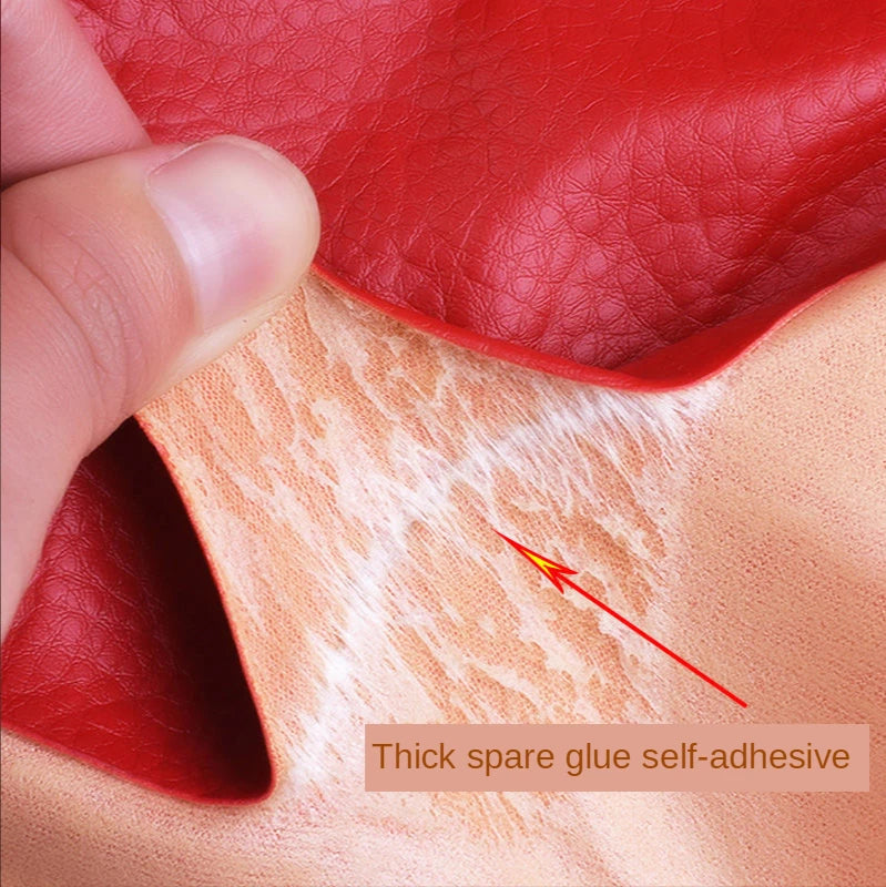A hand is applying a thick spare glue self-adhesive patch onto a piece of leather or fabric.