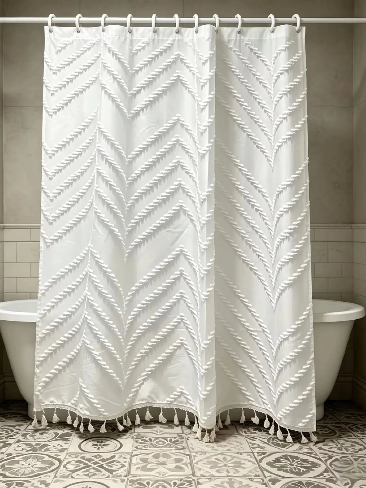 White shower curtain with a geometric cutout tassel pattern hanging on a rod.