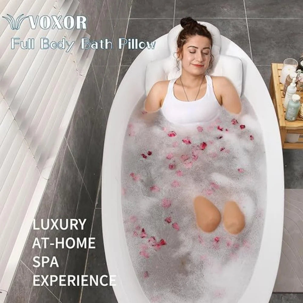 A woman relaxing in a white bath pillow filled with pink bath salts and bubbles for a luxury at-home spa experience.