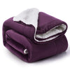 Manta de sherpa morada oscura y extra gruesa enrollada.