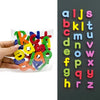 A hand holds a clear plastic bag filled with colorful magnetic alphabet letters for learning.