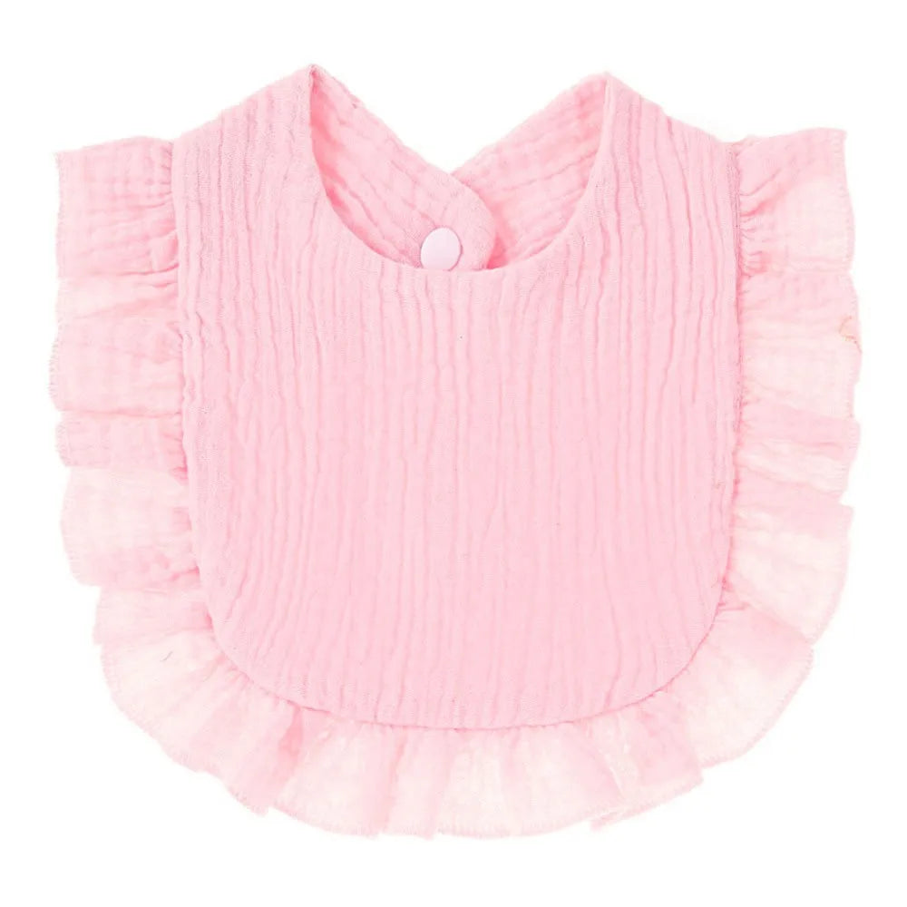 A pink soft cotton baby bib in a bandana style with ruffled edges.