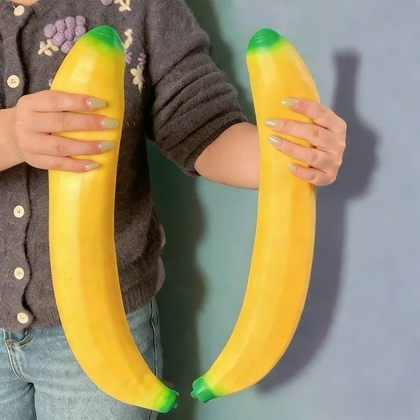Eine Person hält ein leuchtend gelbes Bananen-Fidget-Spielzeug vor einem gedämpften blaugrünen Hintergrund.