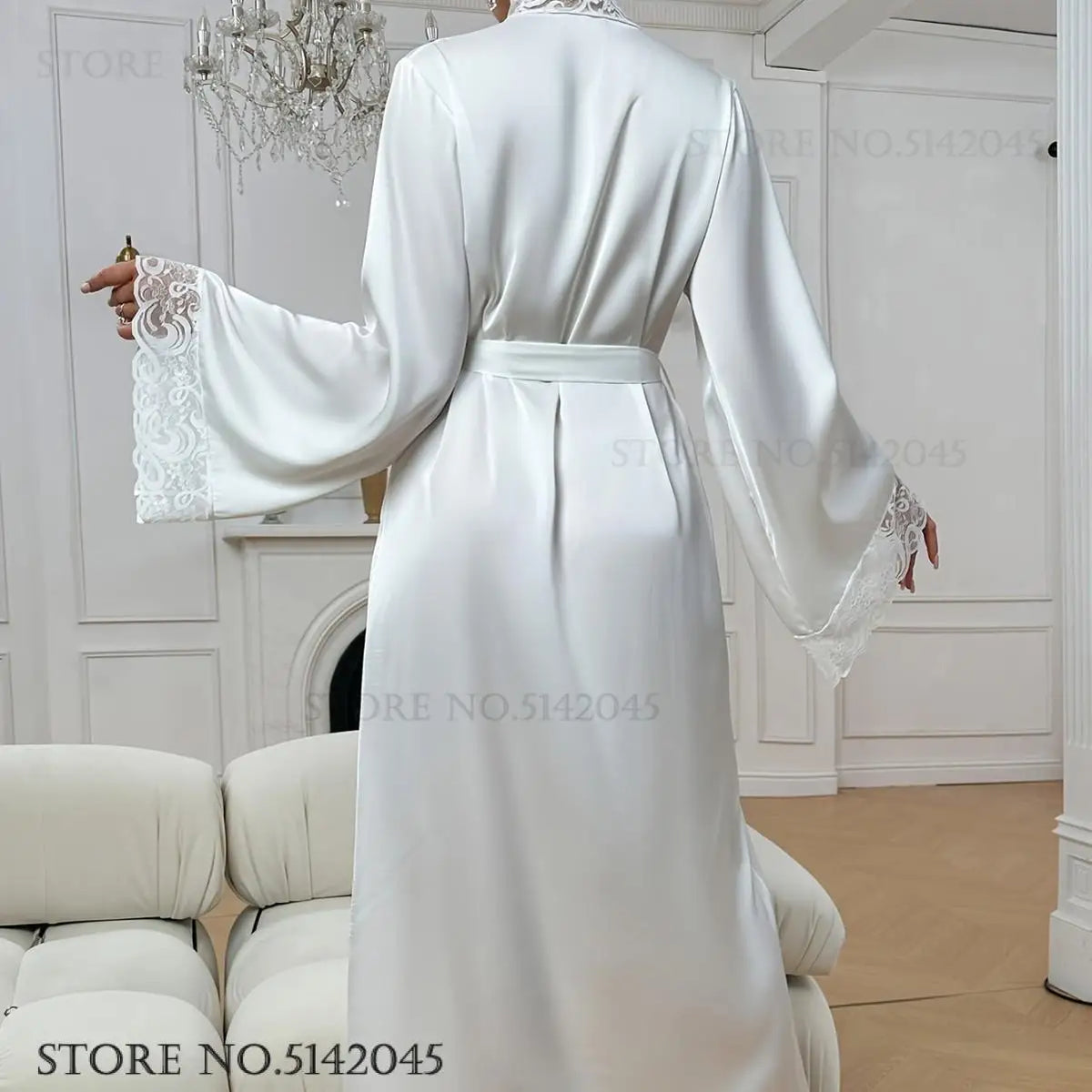 A woman wearing a long white silk satin robe with lace trim, shown from the back.