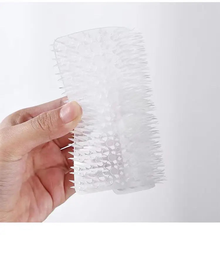 Une main tient un ensemble de tampons à vaisselle en silicone et brosse à fissures.