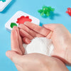 Hands holding white craft powder with colorful plastic sea creatures on a blue background