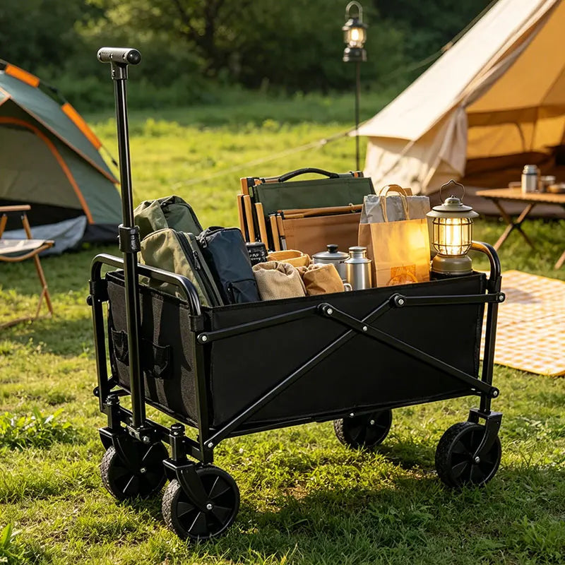 Une remorque de camping noire pliable avec des roues tout-terrain est garée sur une pelouse à côté d'une tente.