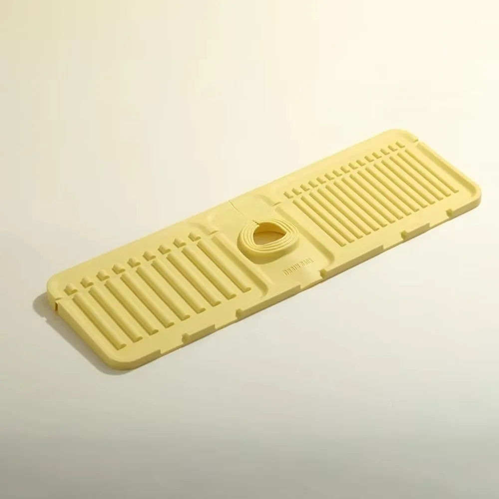 A yellow silicone faucet draining mat with raised ridges and a central drain hole.