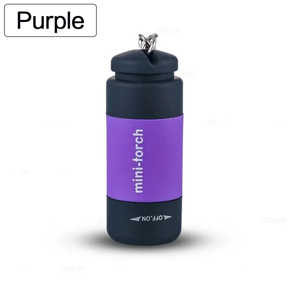 A purple mini-torch keychain flashlight with a silver cap and black body.