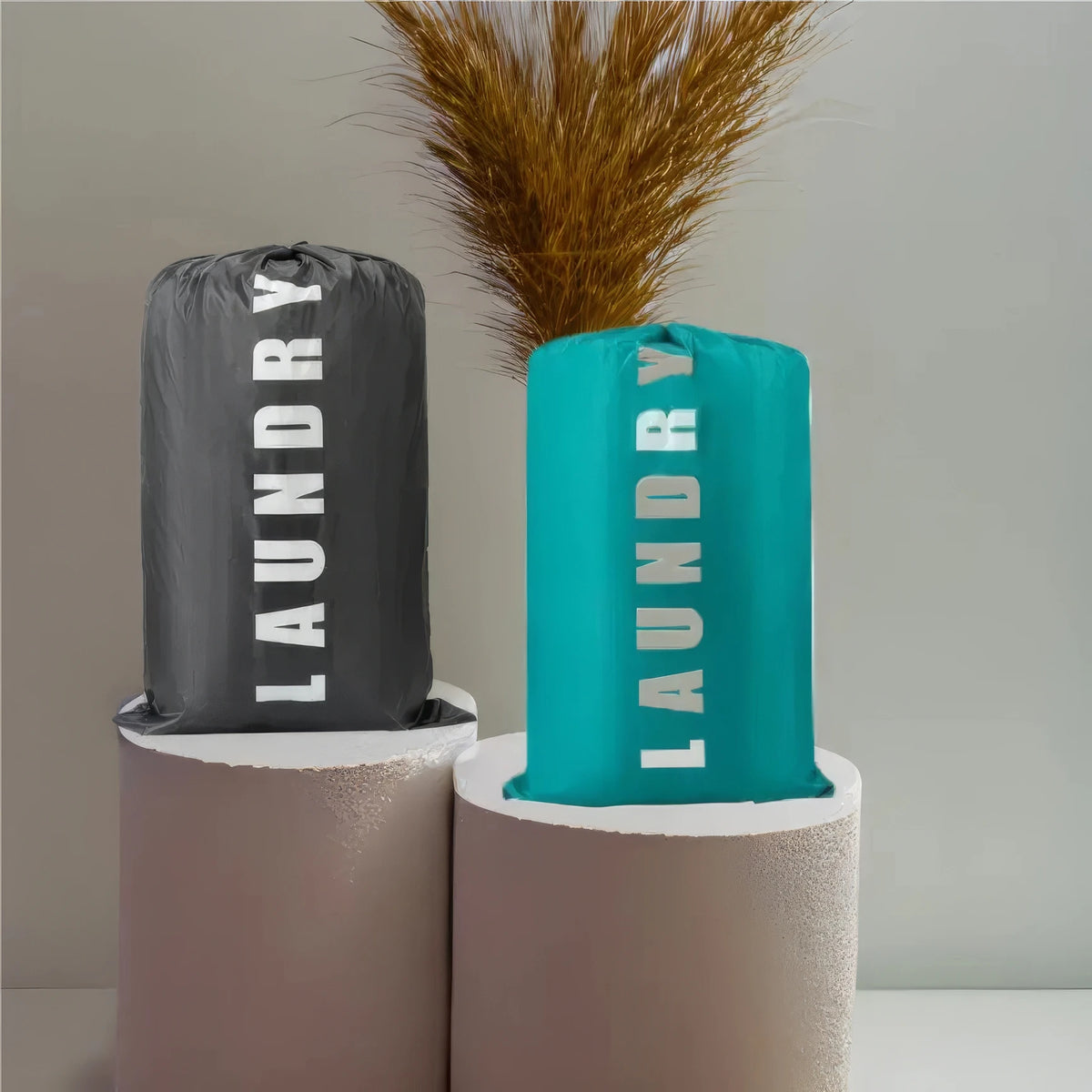 Reusable laundry storage bags in black and teal with drawstring closures displayed against a light gray background.