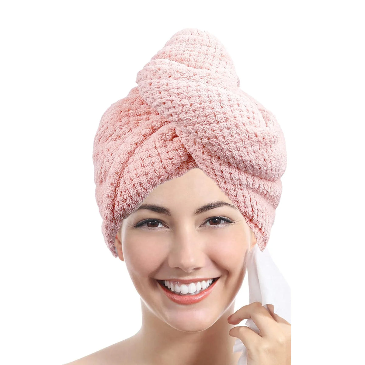 A woman is smiling while wearing a pink, textured microfiber hair towel wrap.