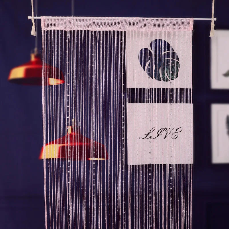 A sheer pink beaded string curtain hangs vertically against a dark blue background.