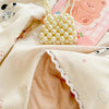 A light beige lace-trimmed breathable summer duvet with a pearl necklace and pink patterned fabric.