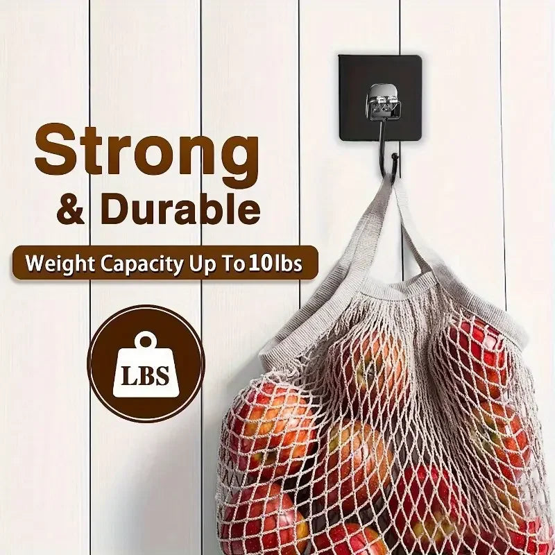 A mesh storage bag filled with fresh fruit hanging from a black adhesive hook.