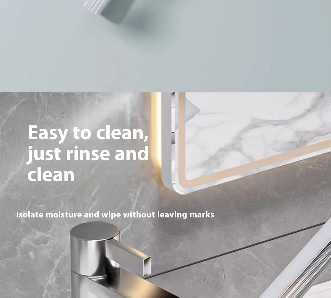 A silicone scraper broom and squeegee used for cleaning, shown next to a marble surface.