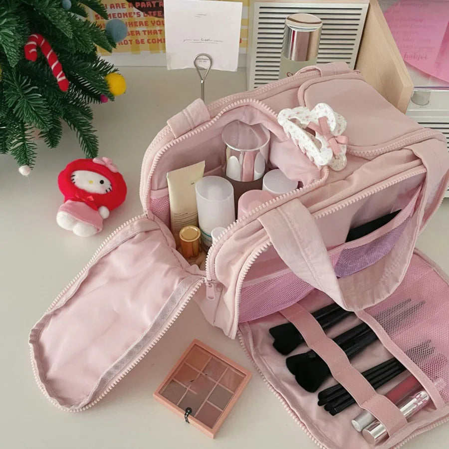 A pink cosmetic travel organizer bag with multiple compartments and a separate pouch for makeup brushes.
