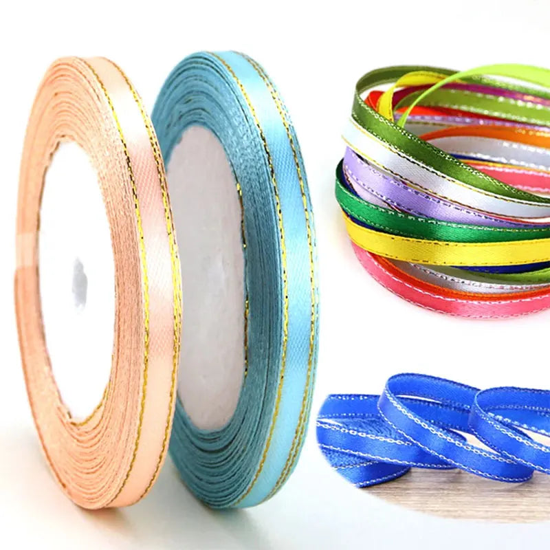 Rolls of gold-edge satin ribbon in various colors, including teal and yellow, for crafts and decor.