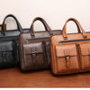 Drei braune und schwarze Herren-Leder-Business-Briefcases auf einer Holzoberfläche.
