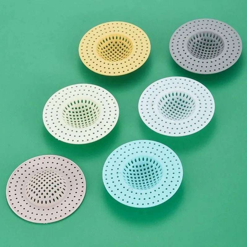 Five circular silicone sink drain filters in various pastel colors including yellow, gray, white, and pink