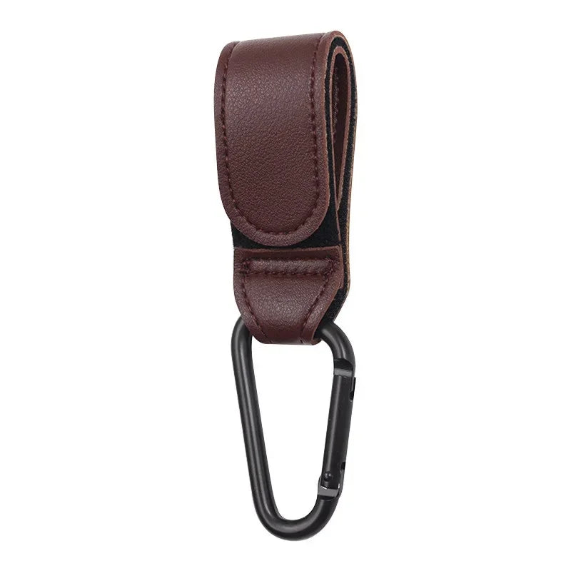 A brown PU leather stroller hook with a black loop for organizing baby bags.
