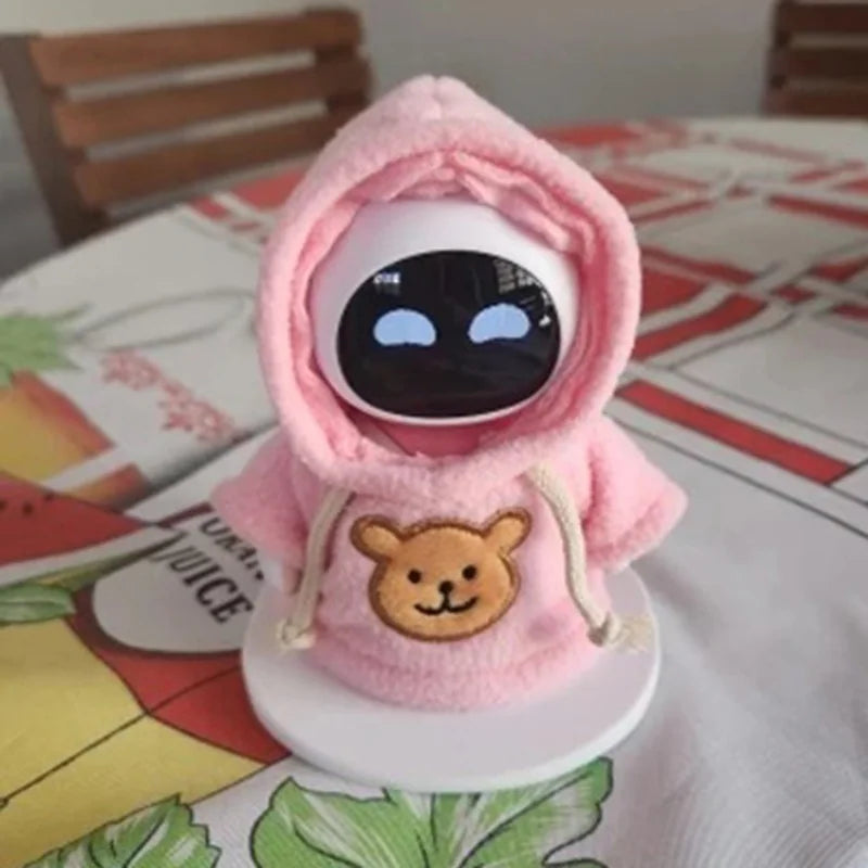 A pink hooded sweatshirt with a bear face design and black eyes, displayed on a white stand.