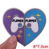 A pair of heart-shaped embroidered iron-on patches featuring a white controller design with the word PLAYER on each half.