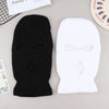 Black and white knitted ski mask car headrest covers displayed on a light gray surface.