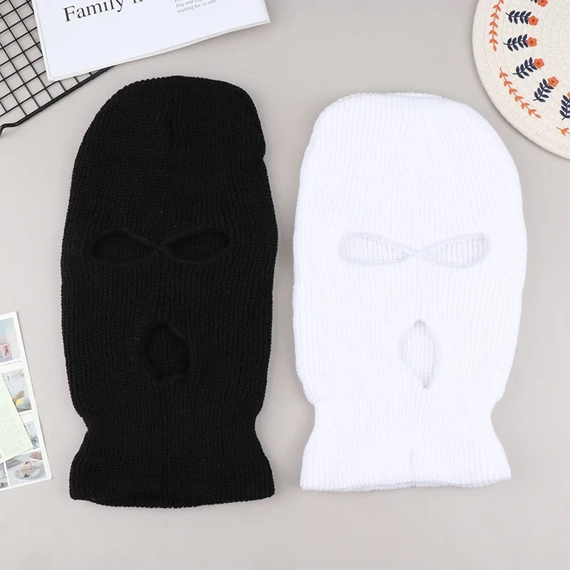 Black and white knitted ski mask car headrest covers displayed on a light gray surface.