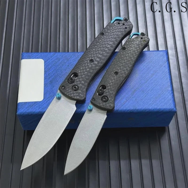 A carbon fiber folding knife with an axis lock is displayed on a blue box.