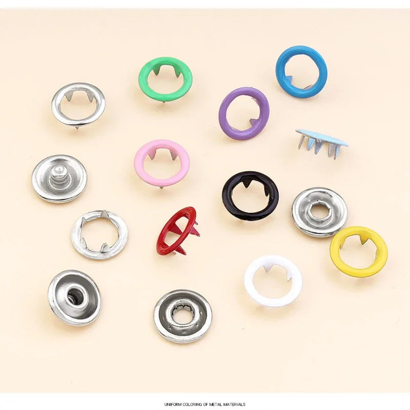 Colección de hebillas y pinzas metálicas con garras de varios colores para ropa y bolsos.