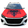 A white car with a red hood cover featuring a black Polish eagle design.