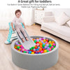 A plastic slide toy is positioned next to a large gray bowl filled with colorful non-toxic ball pit balls for toddlers.