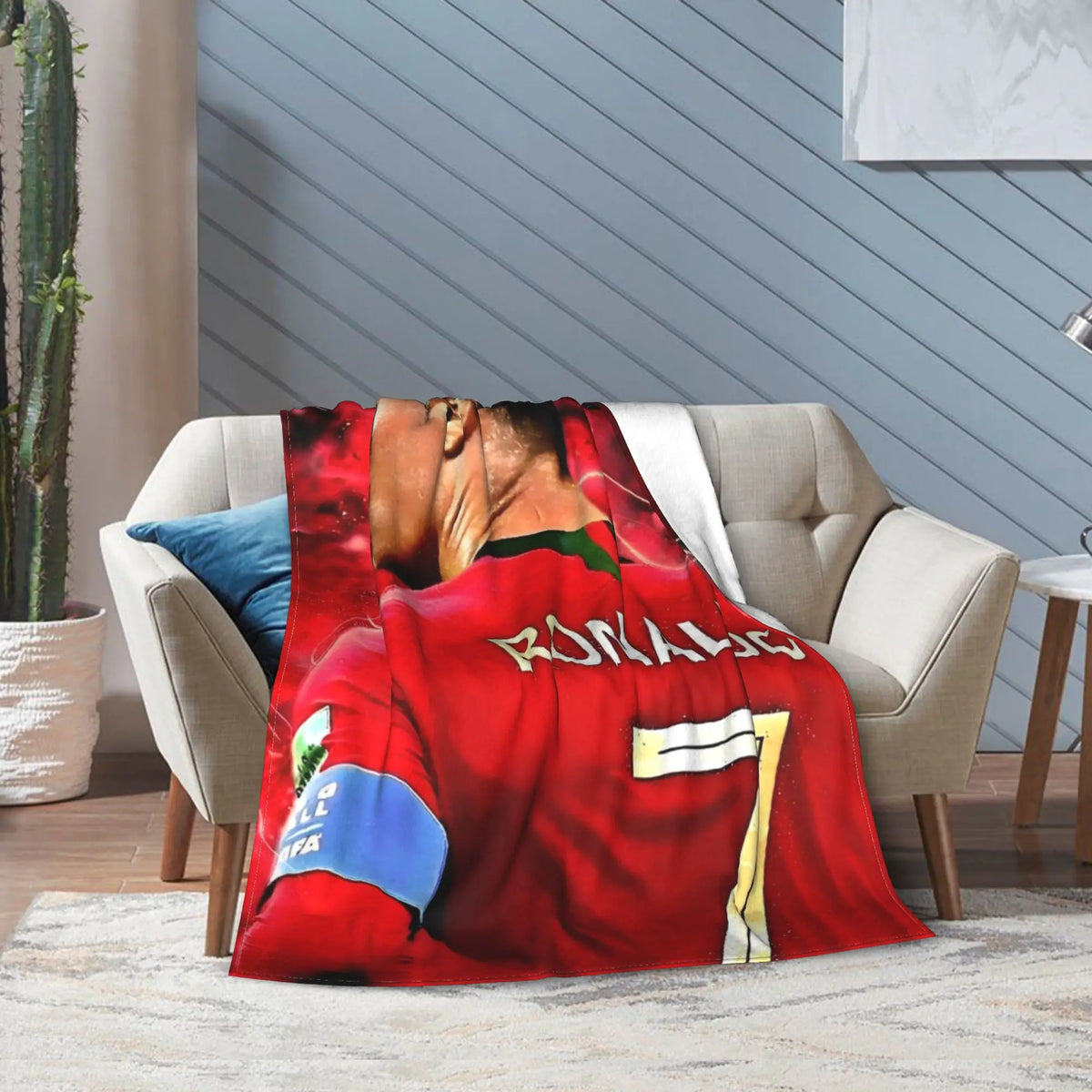 Rote Fußballtrikot-Wolldecke über einem hellgrauen Sofa