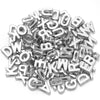 Haufen silberner Metall-Buchstabenperlen in verschiedenen Schriftarten für DIY-Bastelarbeiten