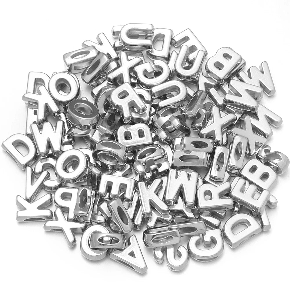 Haufen silberner Metall-Buchstabenperlen in verschiedenen Schriftarten für DIY-Bastelarbeiten